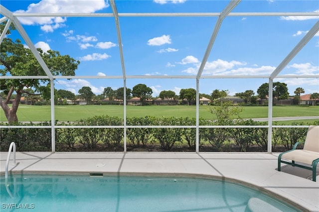 view of pool with glass enclosure and a patio