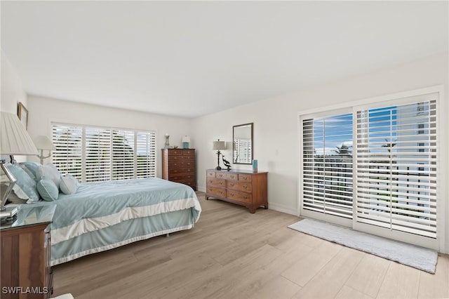 bedroom with light wood-type flooring and access to outside