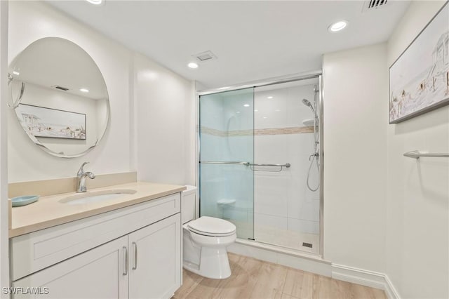 bathroom with wood-type flooring, vanity, toilet, and walk in shower