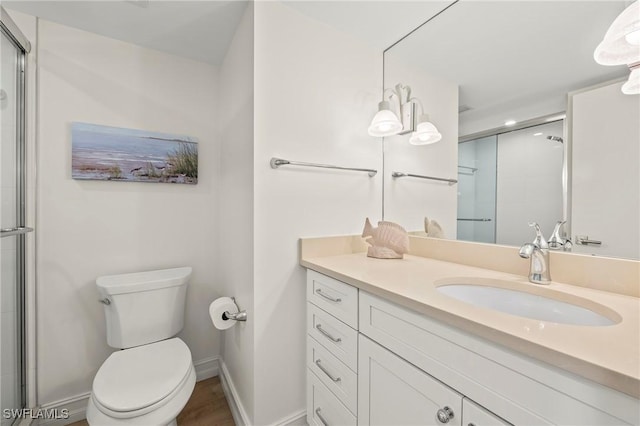 bathroom with vanity, toilet, and a shower with shower door