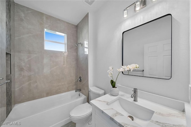 full bathroom featuring tiled shower / bath combo, toilet, and vanity