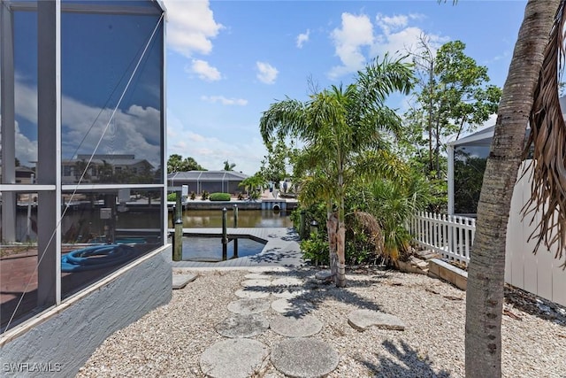 view of dock with glass enclosure and a water view