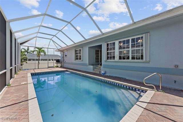 view of swimming pool with glass enclosure and a patio area