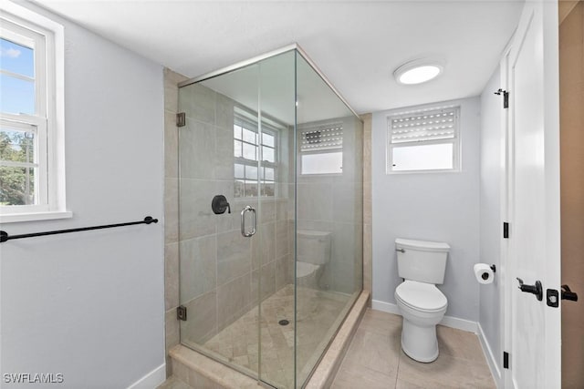 bathroom featuring tile patterned floors, a shower with door, and toilet