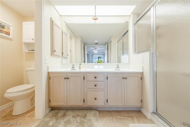 bathroom featuring tile patterned floors, vanity, toilet, and walk in shower