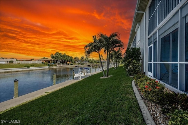 yard at dusk featuring a water view