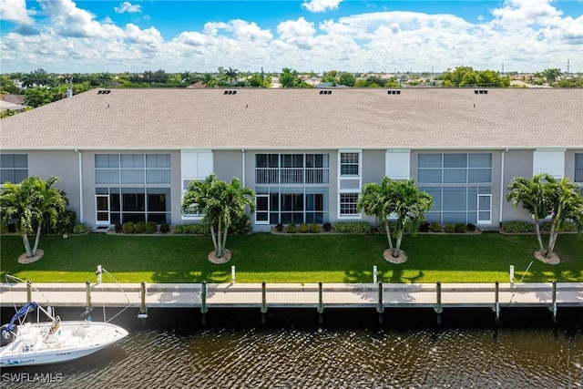 back of house with a water view and a yard