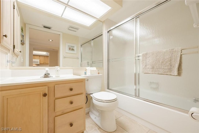 full bathroom featuring shower / bath combination with glass door, tile patterned flooring, vanity, and toilet