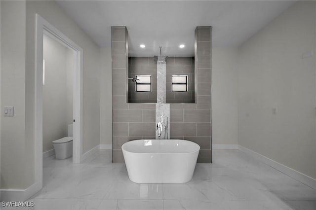 bathroom with a washtub, toilet, and tile walls