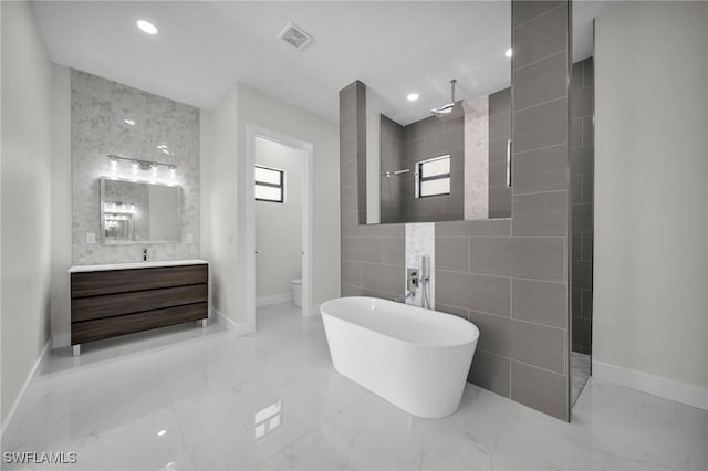 full bathroom with vanity, separate shower and tub, toilet, and tile walls