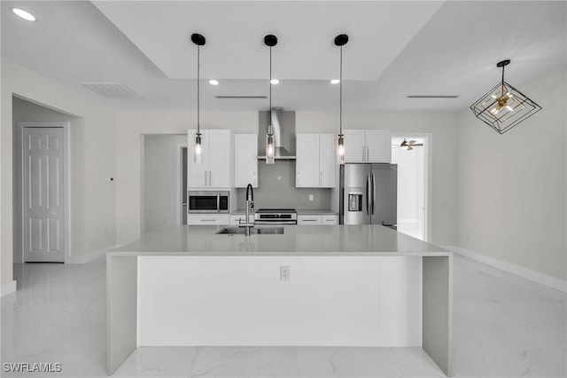 kitchen featuring sink, white cabinetry, stainless steel appliances, and wall chimney range hood