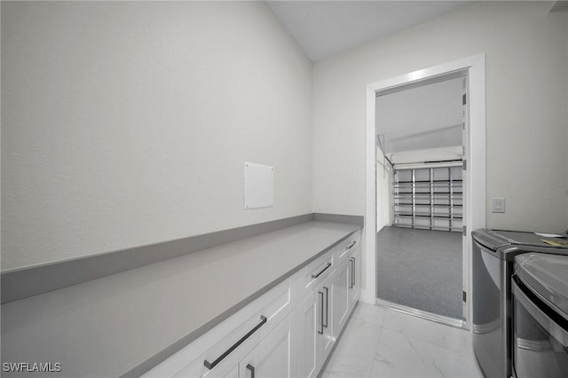 laundry area with cabinets, washing machine and dryer, and light carpet