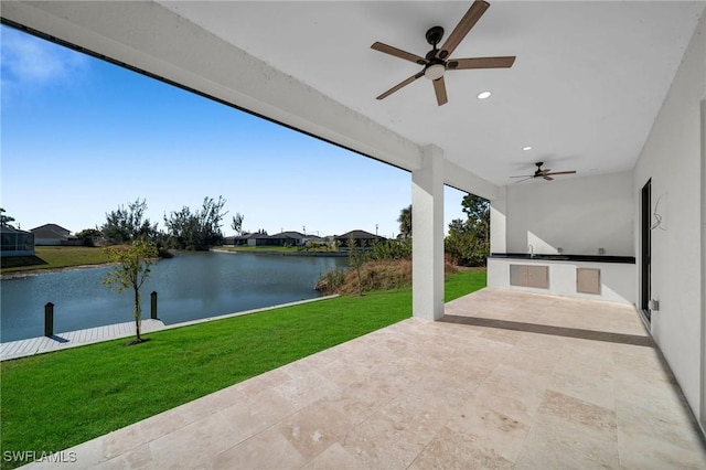 view of patio / terrace with a water view, area for grilling, and ceiling fan