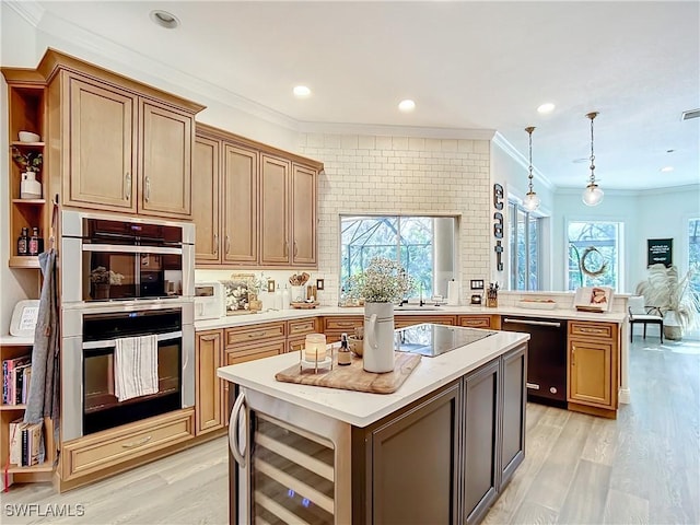 kitchen with black appliances, a center island, beverage cooler, and a wealth of natural light