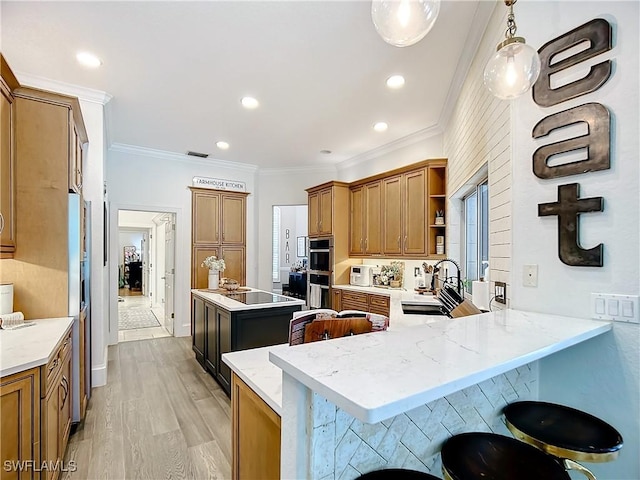 kitchen featuring pendant lighting, a kitchen bar, kitchen peninsula, and light wood-type flooring