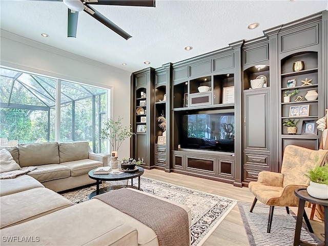 living room featuring ceiling fan, hardwood / wood-style floors, crown molding, and a textured ceiling