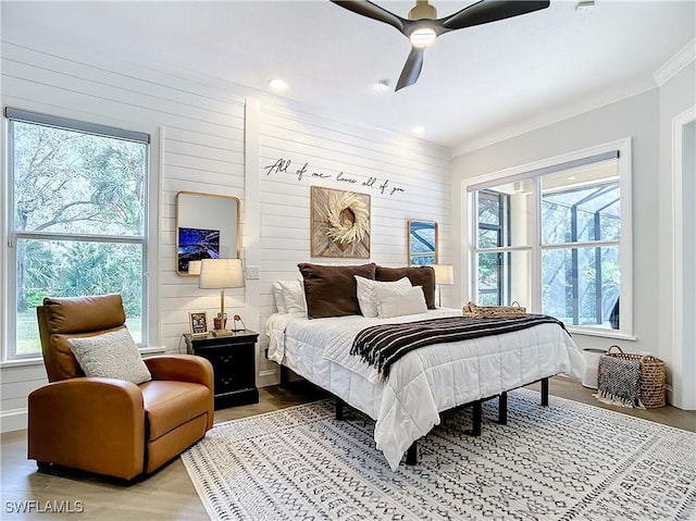 bedroom with ceiling fan, crown molding, and wood-type flooring