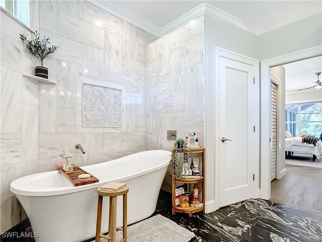 bathroom with a bath, tile walls, and crown molding