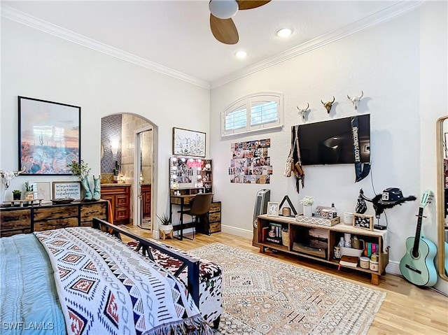 bedroom with ceiling fan, hardwood / wood-style floors, ensuite bathroom, and ornamental molding