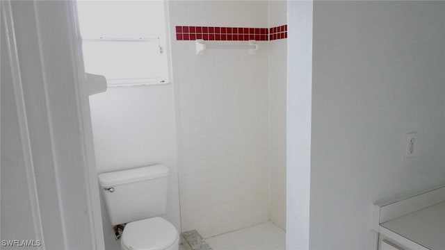 bathroom featuring toilet and tiled shower