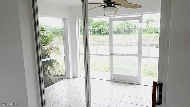 doorway with ceiling fan, a healthy amount of sunlight, and light tile patterned flooring