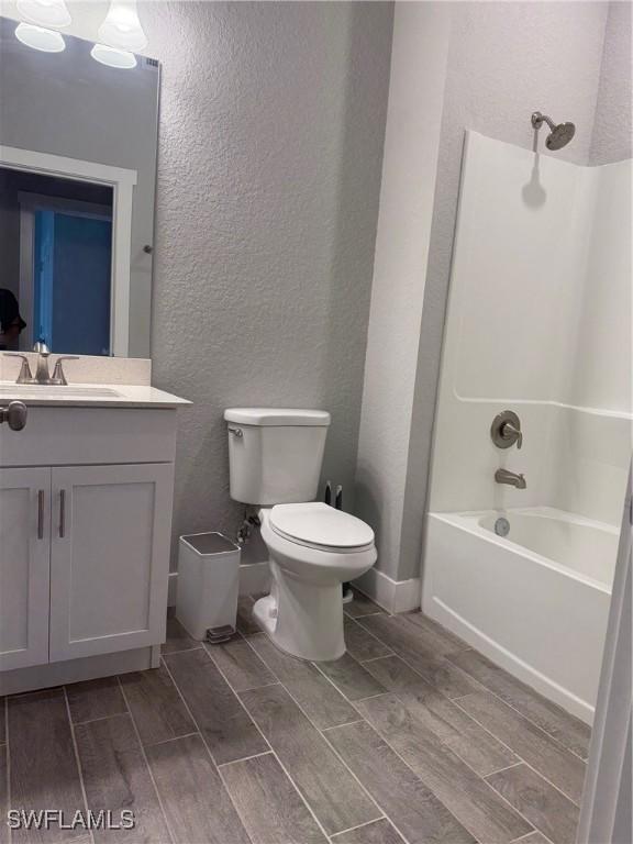 full bathroom featuring vanity, shower / bath combination, hardwood / wood-style flooring, and toilet