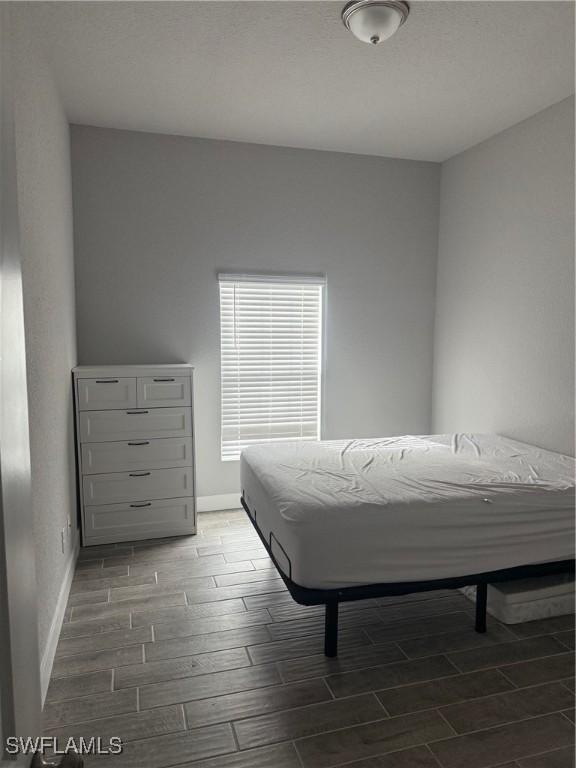 bedroom with dark hardwood / wood-style floors