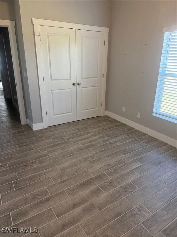 unfurnished bedroom with a closet and dark wood-type flooring