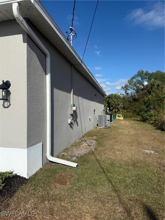 view of property exterior featuring a lawn and central AC