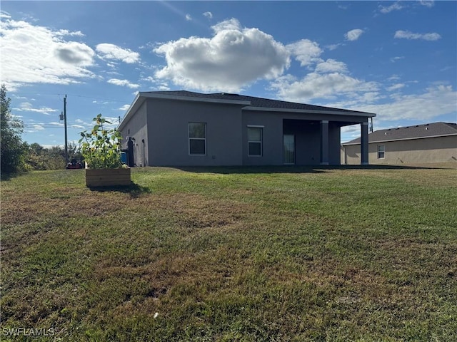 rear view of property featuring a lawn