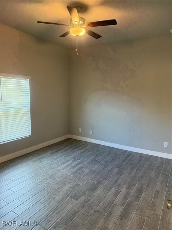 spare room with dark hardwood / wood-style floors and ceiling fan