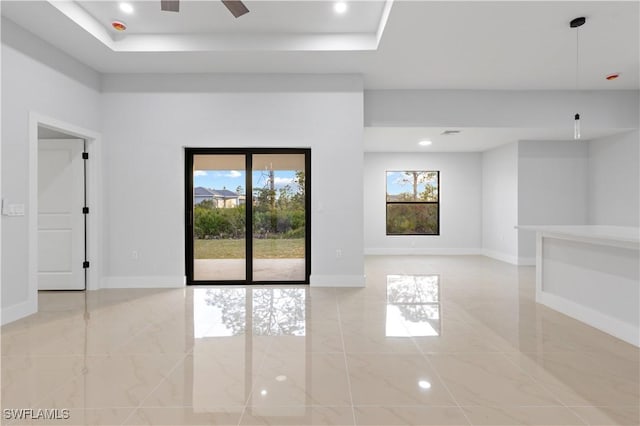 unfurnished room with a raised ceiling and ceiling fan