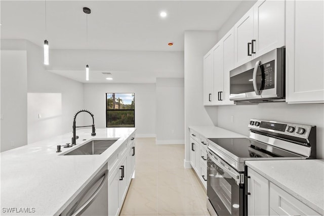 kitchen with white cabinets, appliances with stainless steel finishes, hanging light fixtures, and sink