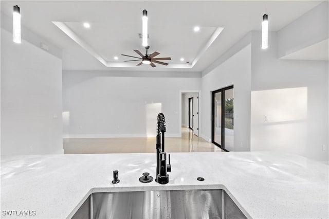 room details with sink, a raised ceiling, hanging light fixtures, and ceiling fan