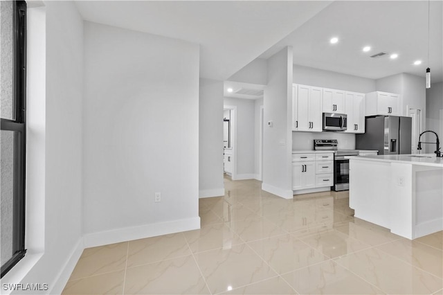 kitchen featuring appliances with stainless steel finishes, white cabinetry, and sink