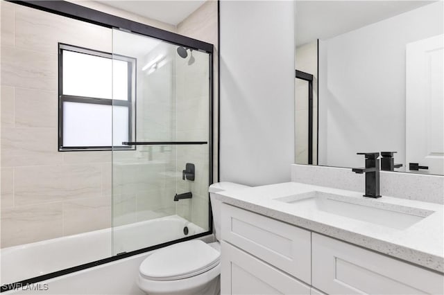 full bathroom featuring shower / bath combination with glass door, vanity, and toilet