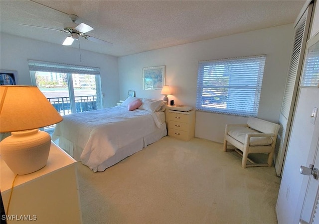 bedroom featuring access to exterior, ceiling fan, light colored carpet, and a textured ceiling