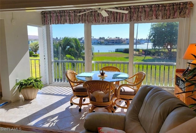 sunroom / solarium with a wealth of natural light, a water view, and ceiling fan