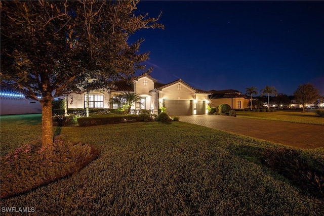 view of front of home with a lawn and a garage