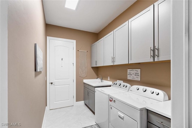 washroom with cabinets, sink, and washing machine and clothes dryer