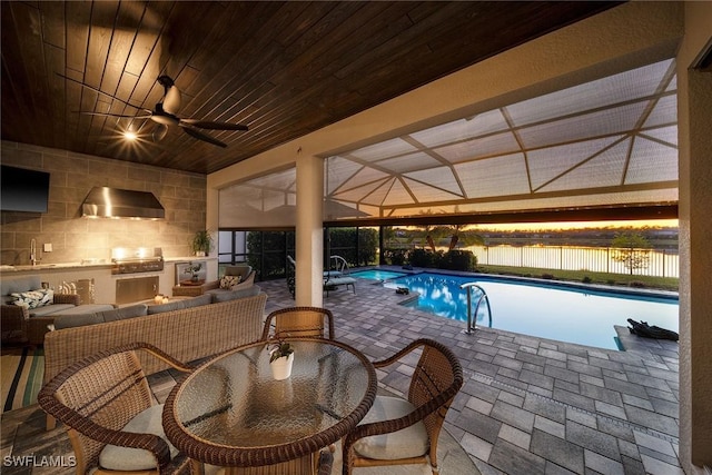 view of pool featuring area for grilling, ceiling fan, grilling area, a patio area, and a water view