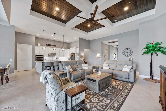 living room featuring ceiling fan, a towering ceiling, and wood ceiling