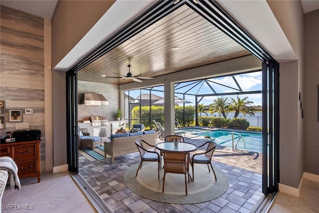 sunroom / solarium with ceiling fan, a water view, and a swimming pool