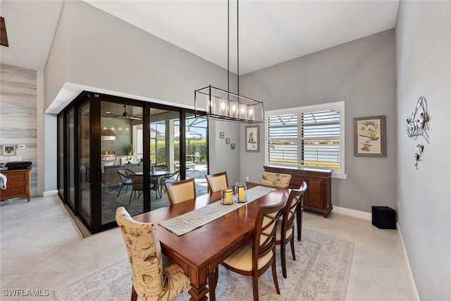 dining room with ceiling fan and high vaulted ceiling