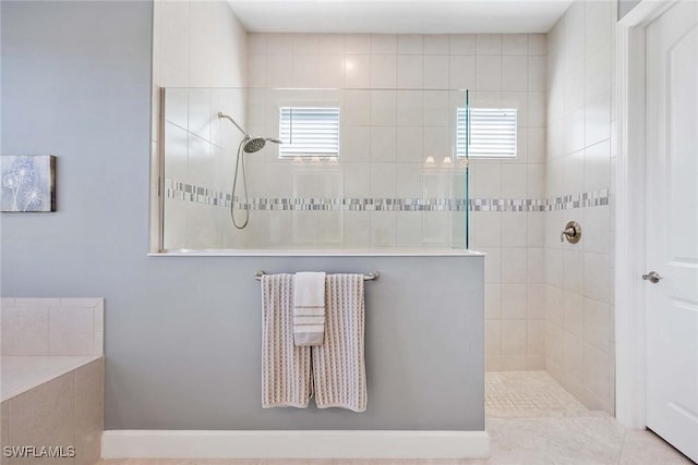 bathroom with tile patterned floors and a tile shower