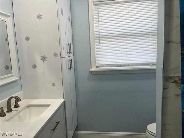 bathroom featuring vanity, toilet, and a shower with shower door