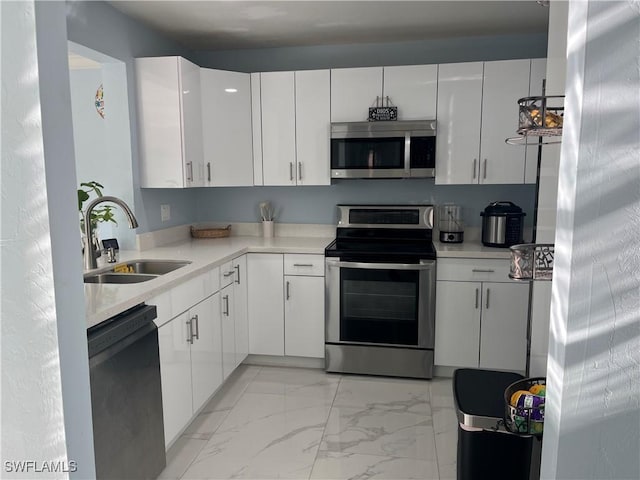 kitchen with white cabinets, stainless steel appliances, and sink