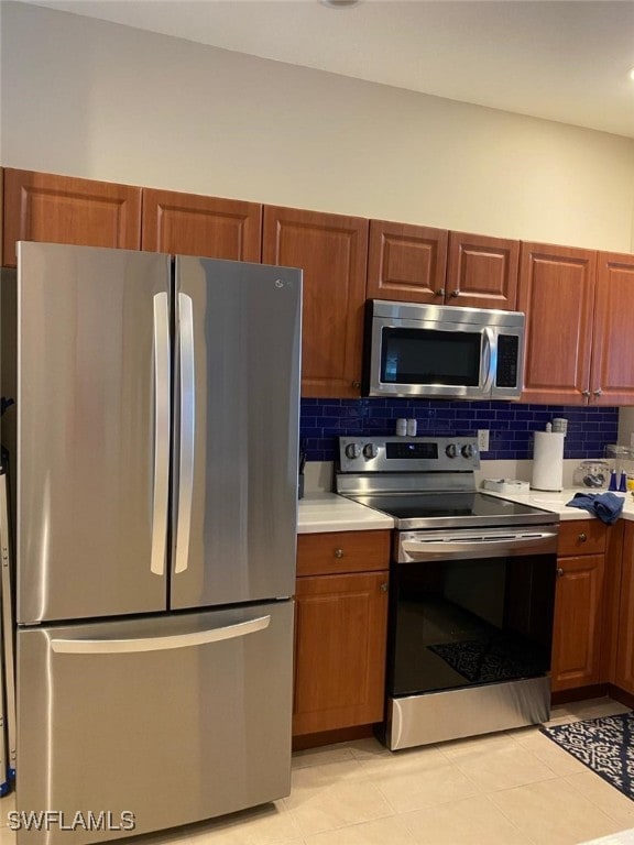 kitchen featuring stainless steel appliances, tasteful backsplash, and light tile patterned floors