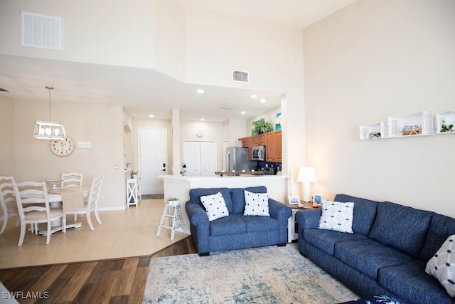 living room featuring light hardwood / wood-style flooring and a high ceiling