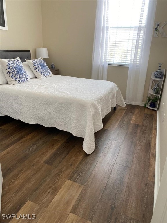 bedroom with dark wood-type flooring